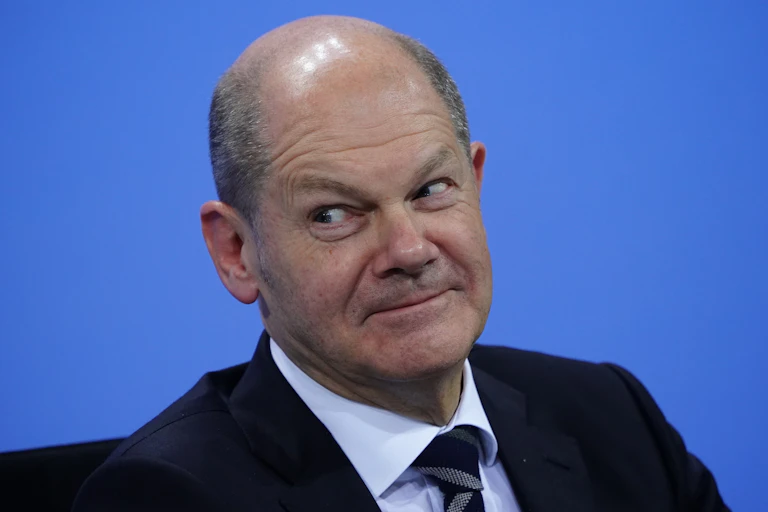 Olaf Scholz smiling at a press conference.