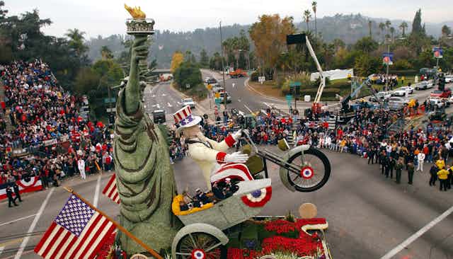 Uncle Sam riding a motorcycle next to Lady Liberty at a parade