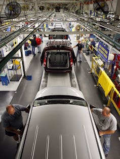 Auto workers assemble a Chrysler minivan.