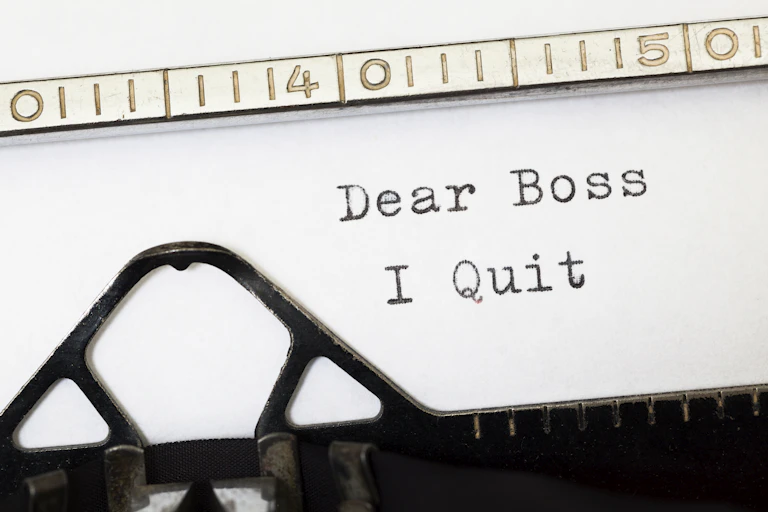 A close up of a piece of paper in a typewriter with the words dear boss I quit
