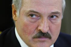 A man with a moustache glares.