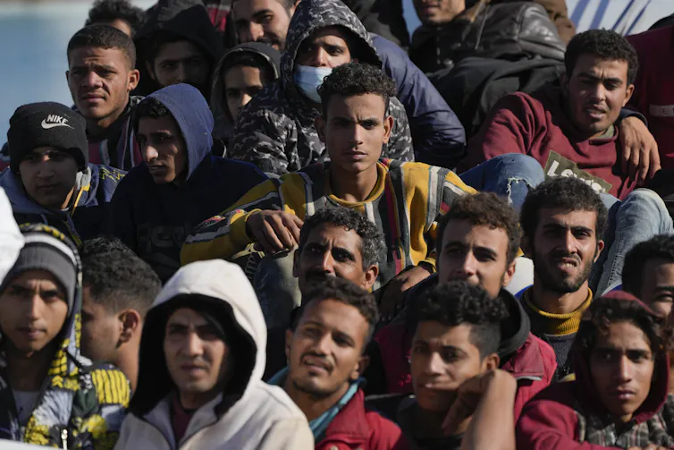 A group of men and boys in a boat.