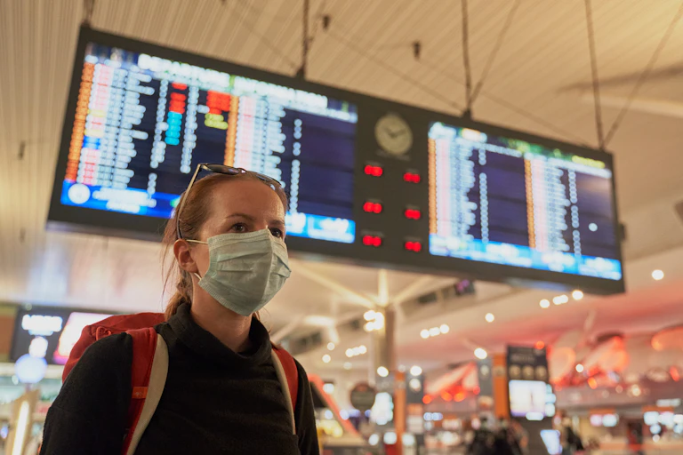 Photo d’une femme portant un masque chirurgical dans un aéroport