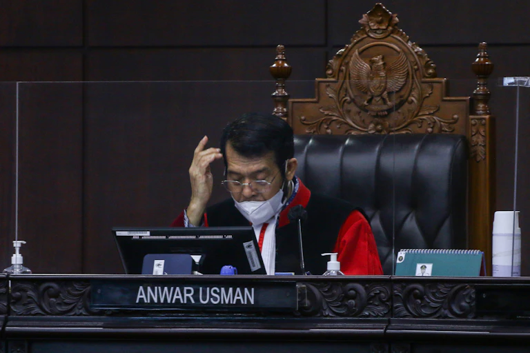 Seorang hakim laki-laki duduk di meja persidangan