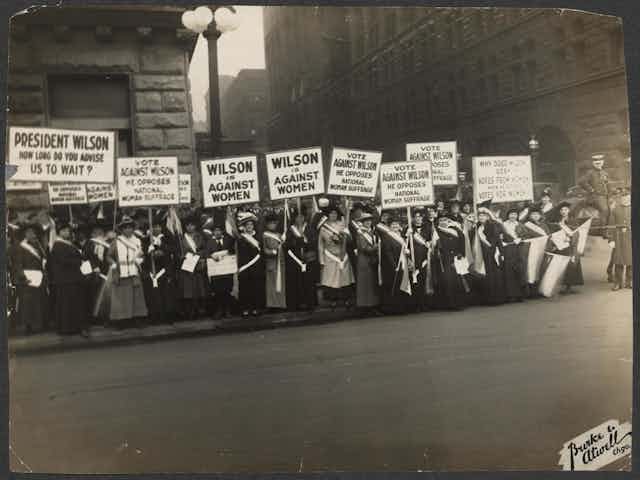 Women protest holding signs