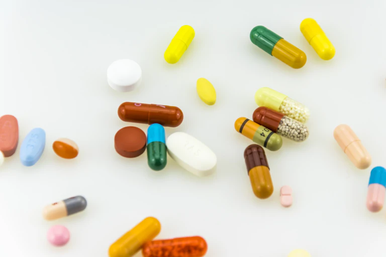 Various pills and capsules against a white background