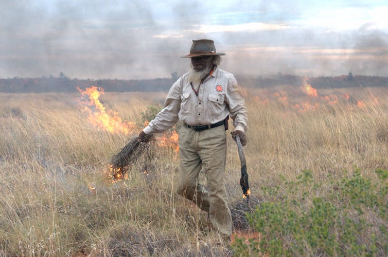 Indigenous man burning country