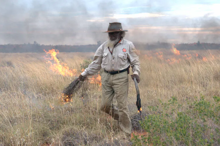 Indigenous man burning country