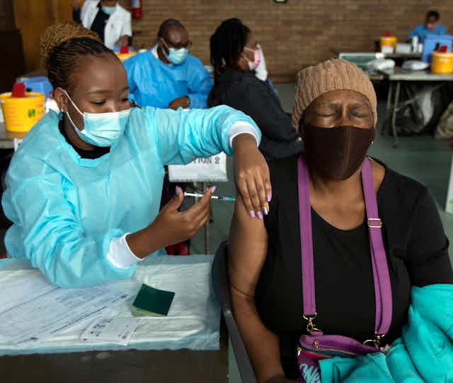 A woman receives Pfizer vaccine in South Africa.