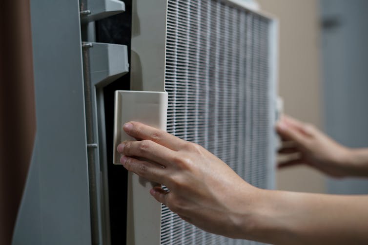 A person changing a filter sheet on a Hepa device