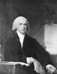 The presidential portrait of James Madison, white-haired, wearing a white shirt and black jacket