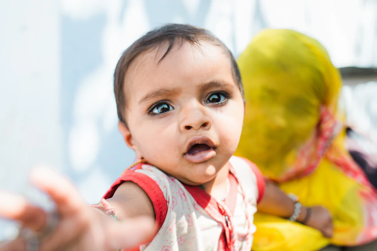 A photo of a little girl in the Indian subcontinent looking piercingly at the camera.