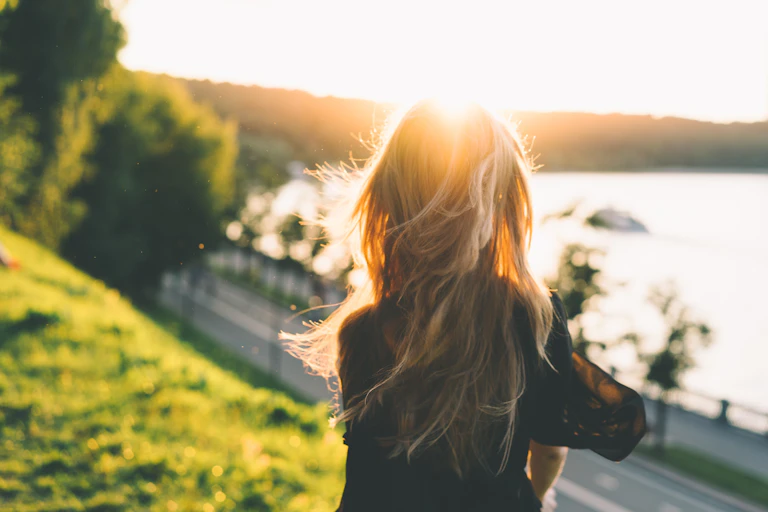 Woman's back as she faces the sun.