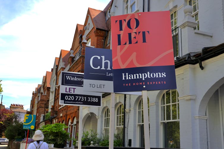 Real estate agent To let signs in front of terraced houses in London