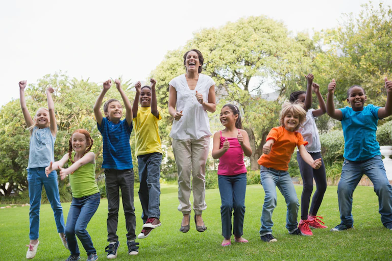 Teacher and pupils jumping outside