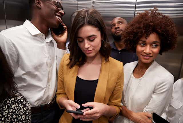Personne blanche entourée de personnes noires dans un ascenseur.