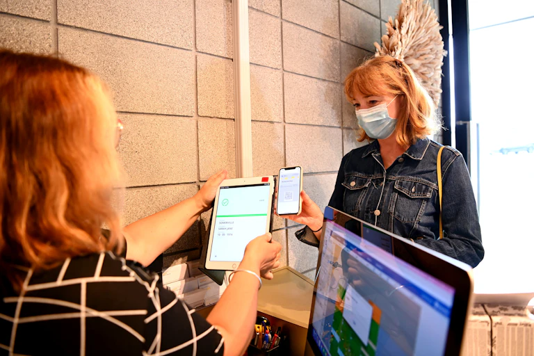Business staff checking a customer's vaccine passport