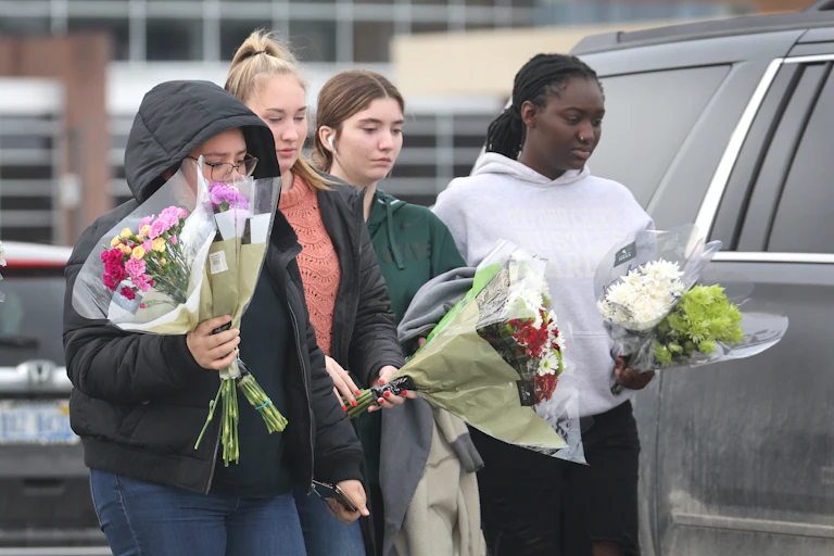 A group of girls carry flowers in their hands.