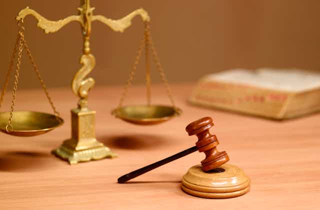A judge's gavel in front of the scales of justice