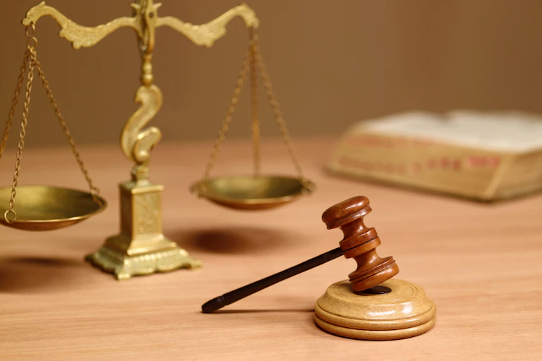 A judge's gavel in front of the scales of justice