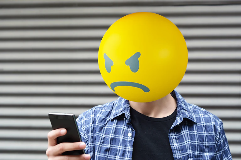 Photoillustration of man with angry emoji head.