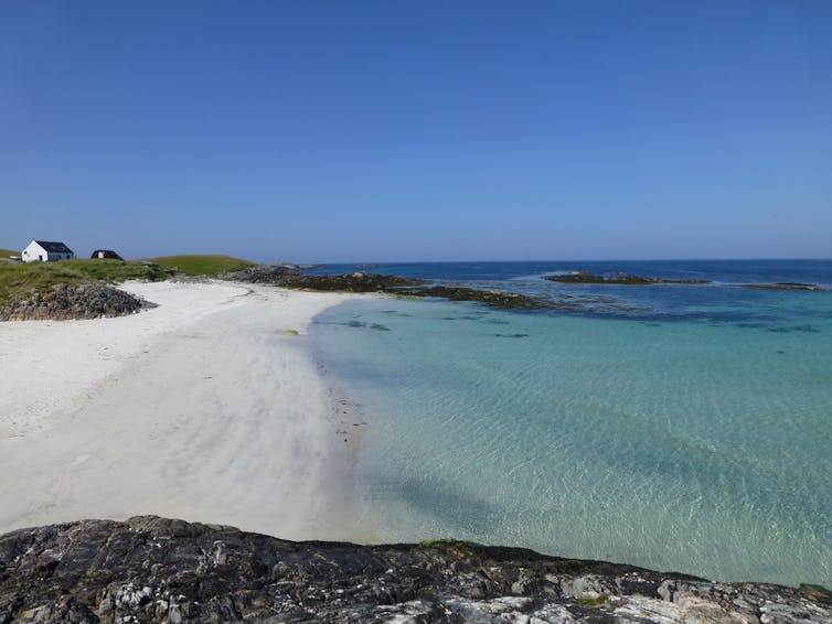 A beach fringing turquoise waters on the Hebridean island of Tiree off the West Coast of Scotland.