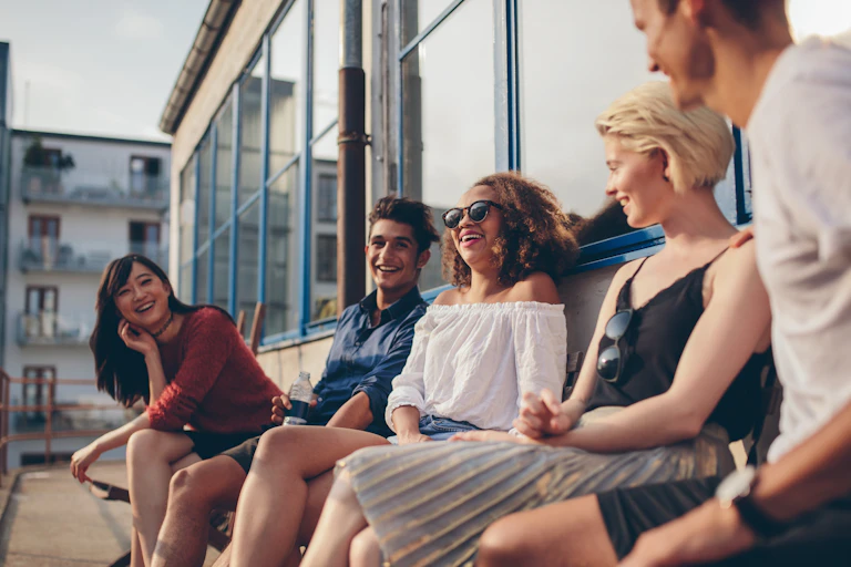 A group of friends sitting on a balcony laughing