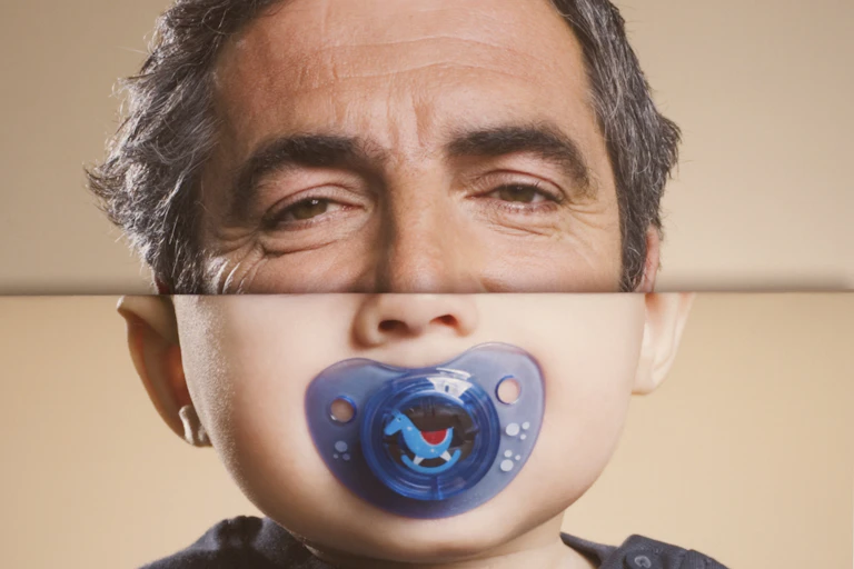 Top half of face a man, bottom half a baby with pacifier.
