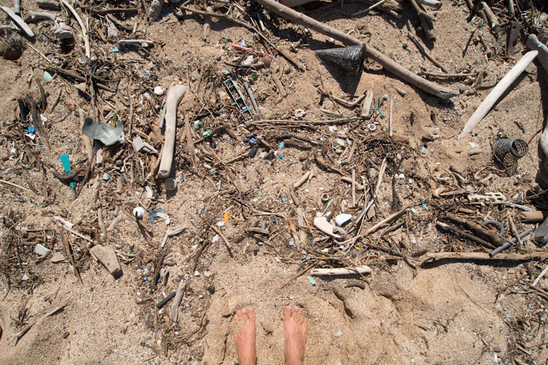Shreds of colored plastic in the sand