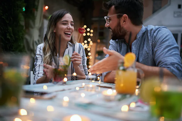 Couple laughing at a bar.