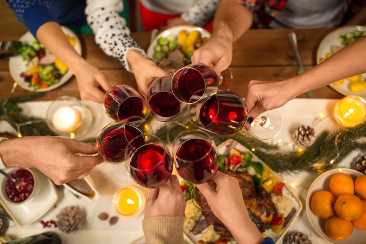 People click wine glasses at a feast
