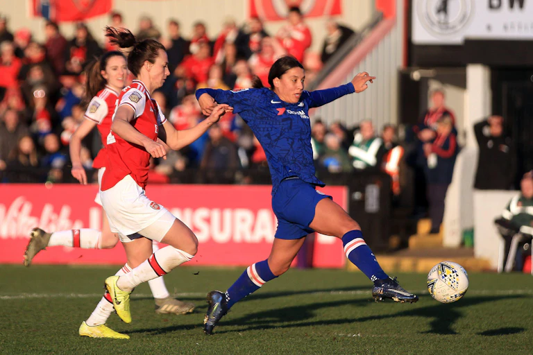 Three women play football.