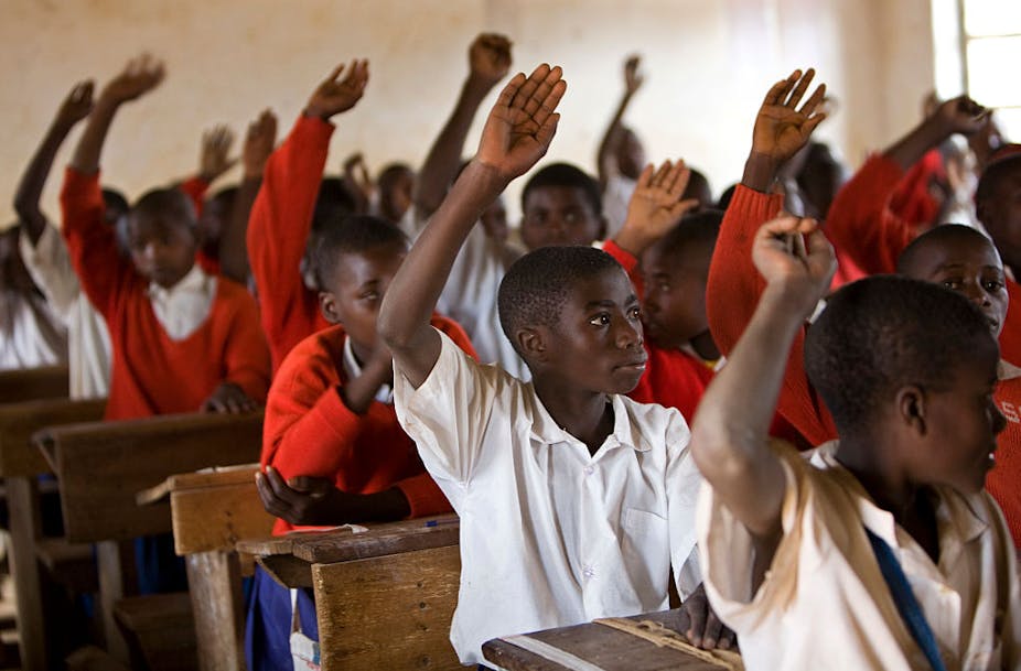 Primary school children put up their hands to answer a question during class in the southern Tanzanian village of Ikuna.