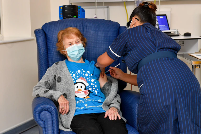 Margaret Keenan receiving the first approved COVID vaccine in the UK
