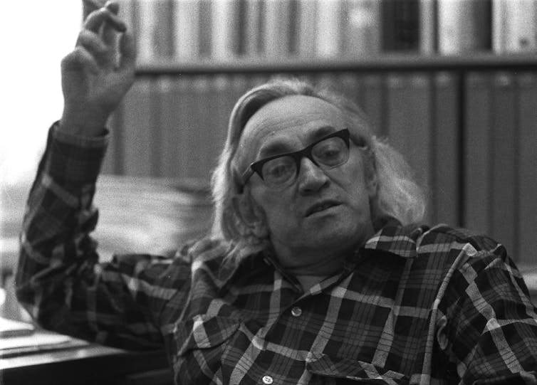 Black and white photo of man with glasses and long grey hair