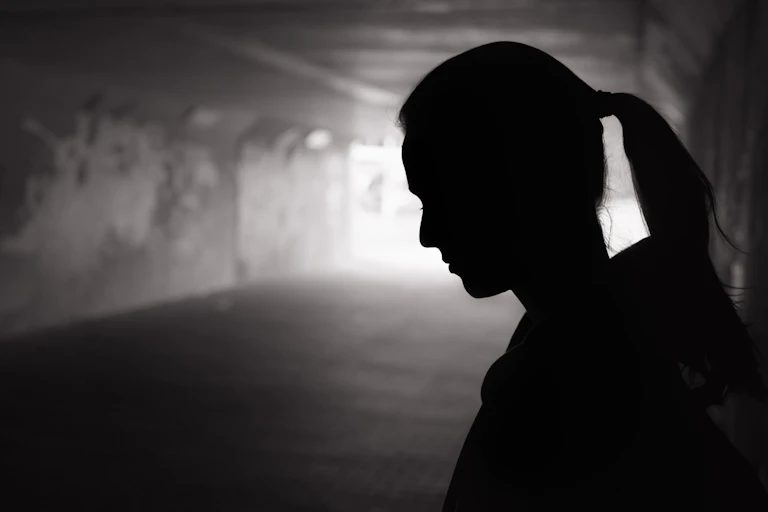 Young woman's profile in a dark underpass.