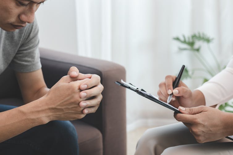 Young man sits with a therapist.