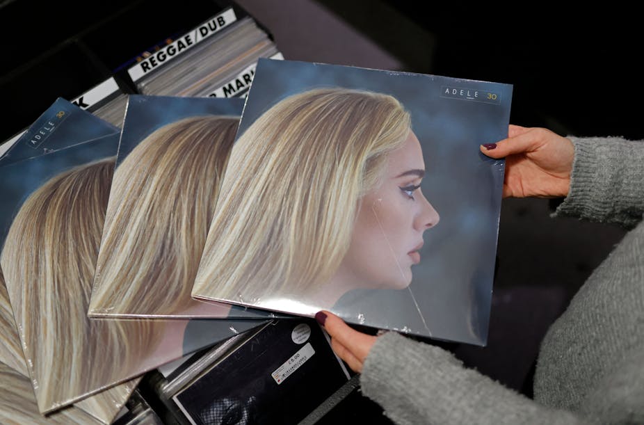 Someone holds copies of Adele's new album '30' in a record shop