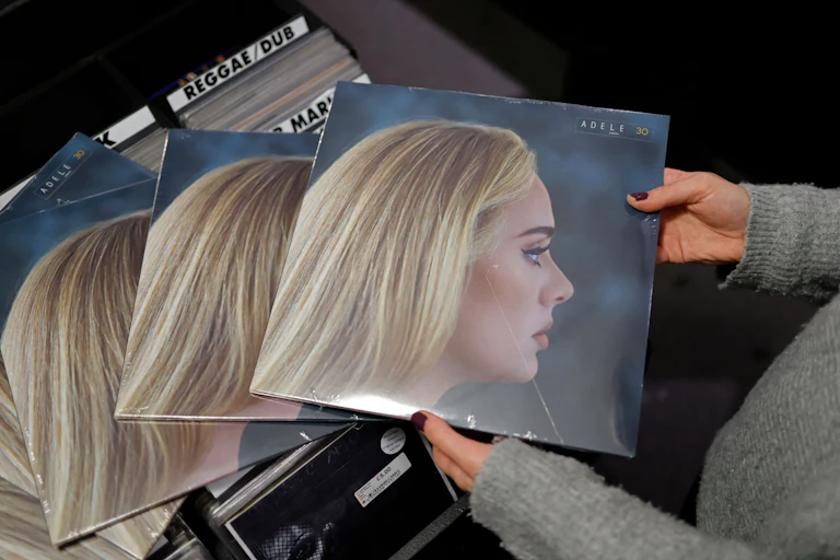 Someone holds copies of Adele's new album '30' in a record shop