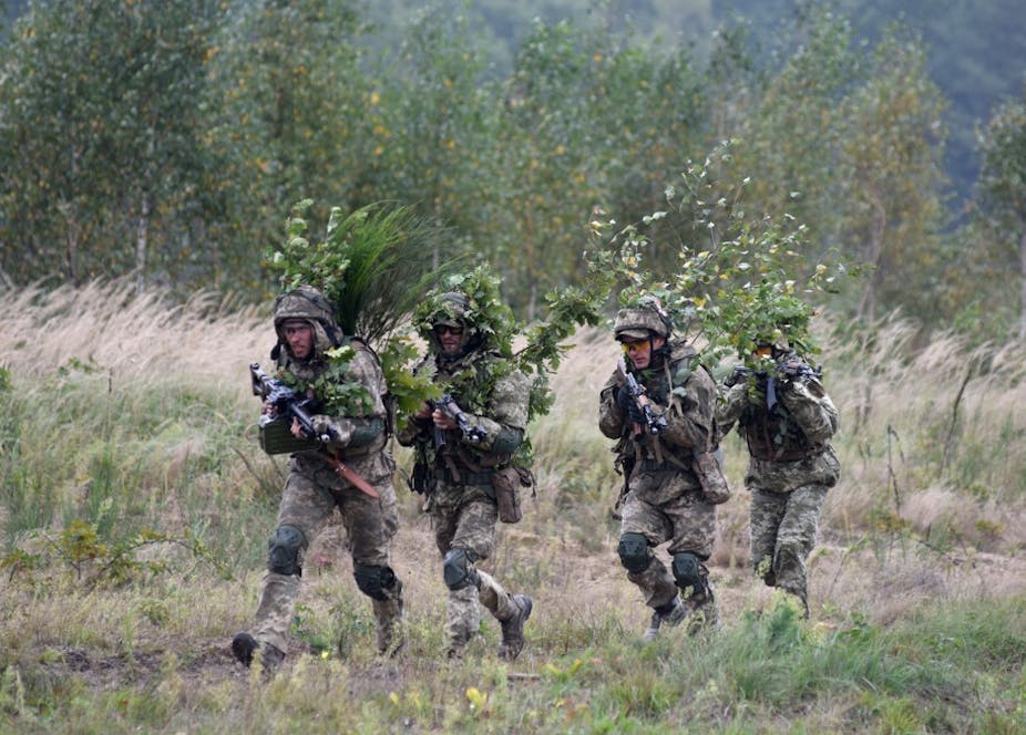 Militaires en tenue de camouflage tenant des fusils mitrailleurs