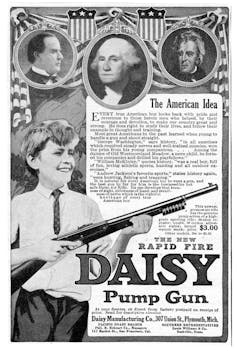 Boy holds BB gun flanked by portraits of U.S. politicians.