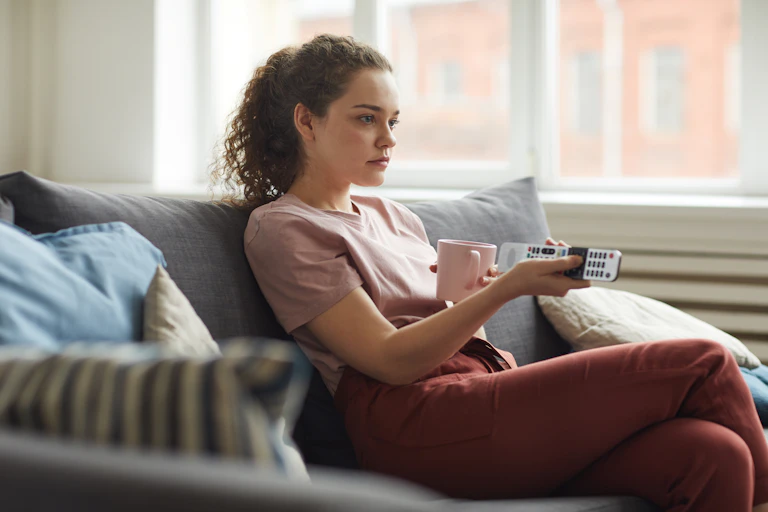 Une jeune femme tient une télécommande