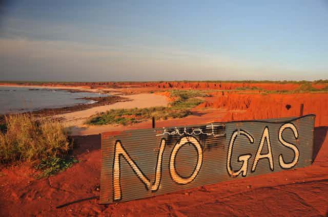 A large sign sitting in red sand reading 'No Gas'