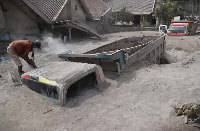 A truck almost completely buried in volcanic ash