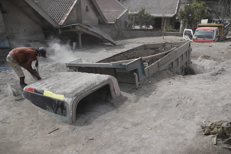 A truck almost completely buried in volcanic ash