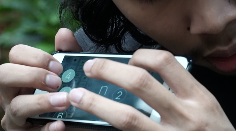 Orang mengoperasikan telpon genggam