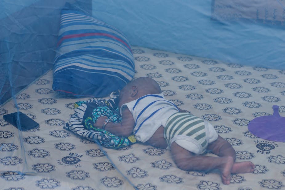 infant sleeping under a bednet 