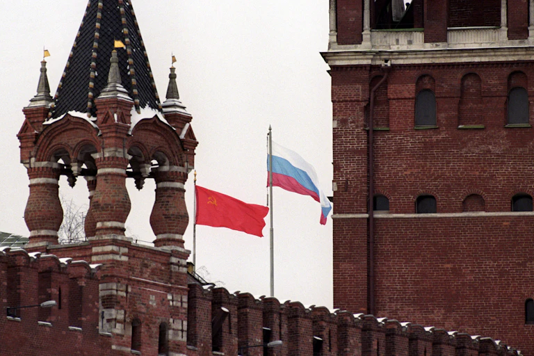 Moscow skyline with the Soviet red flag being taken down and the flag of Russia being raised.