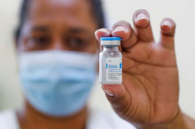 A nurse holding up a vial of Cuba's Abdala COVID vaccine