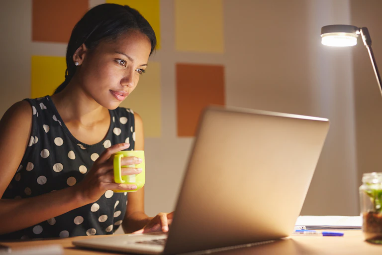 Woman working on her laptop at night